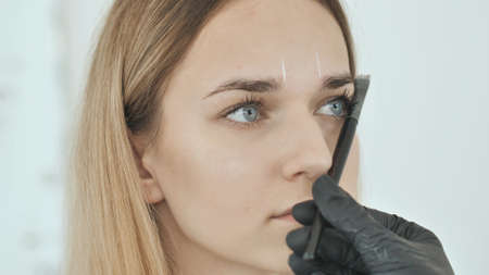 Create permanent eyebrow makeup. Marking the shape of the eyebrows.の写真素材