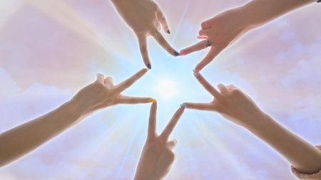 People forming star shape with their fingers against the backdrop of a pink magical sky with shining...