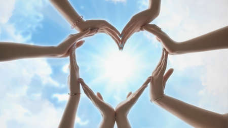 A group of youth makes a heart shape out of their hands.の写真素材