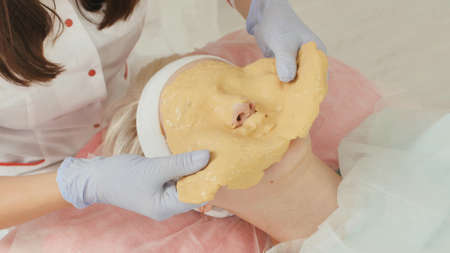 Removing the yellow mask from the womans face.の写真素材