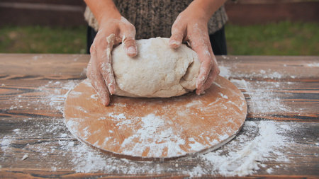 A young woman kneads the dough with her hands. Homemade bread bakingの写真素材
