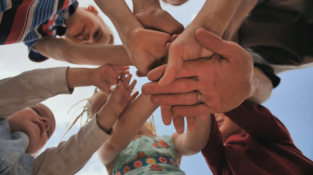 A young family of six join hands together. The concept of a strong and friendly family.