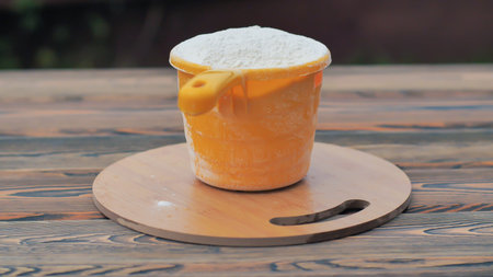 A cup of flour is on the tableの写真素材