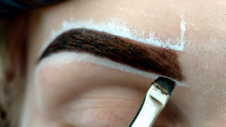 Permanent makeup. Permanent tattooing of eyebrows. Cosmetologist applying permanent make up on eyebrows- eyebrow tattoo.の写真素材
