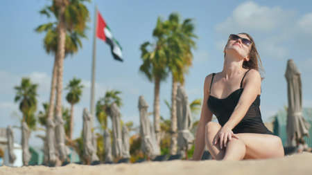 Girl on the beach posing against the backdrop of the UAE flag in Dubai.の写真素材