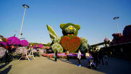 Dubai, UAE - December 14, 2019: Teddy bear holds a big heart in his hands. Dubai Miracle Garden in the UAE. It has over 45 million flowers.のeditorial素材