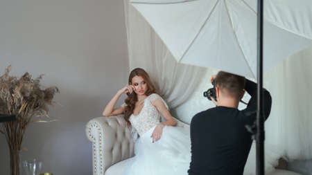 Girl model in a white dress posing in front of the photographer.の写真素材
