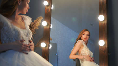 Beautiful girl model posing in front of a mirror.の写真素材