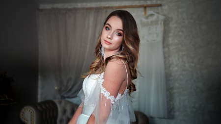 Girl model in a white dress posing in front of the photographer.の写真素材