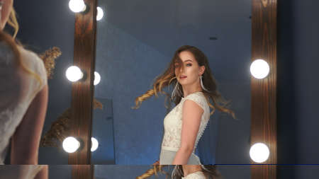 Beautiful girl model posing in front of a mirror.の写真素材