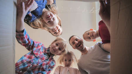 A large family opens the box in their home.の写真素材