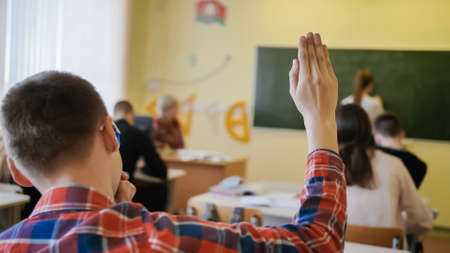 High school student raises his hand during the lesson.の写真素材