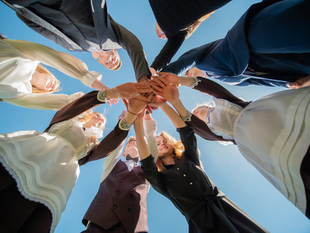 High school students join hands in a sign of strong friendship and graduation.