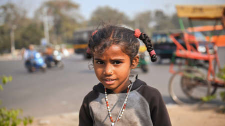 Delhi, India - November 28, 2018: Portraits of a poor child of a girl working and begging on the streets of Delhi.のeditorial素材