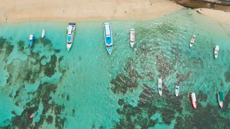 Sea reefs off the coast of the village of Lembongan with boats on the island of Nusa Lembongan. Indonesia. Aerial view.の写真素材