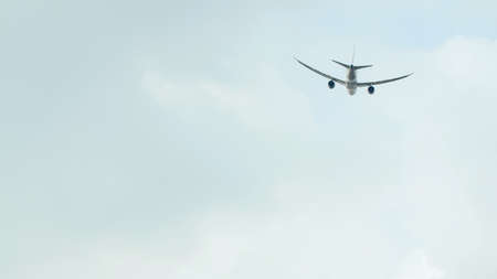 Passenger airplane takes off against the blue sky with cloudsの写真素材