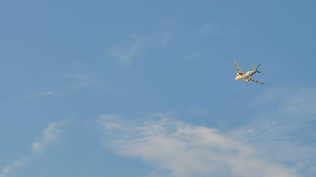 Passenger airplane takes off against the blue sky with clouds