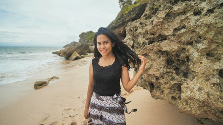 Indonesian girl posing on a beautiful and rocky beach in Bali. Idonezia.