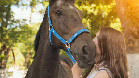 Young seventeen year old girl kisses her beloved horse.の写真素材