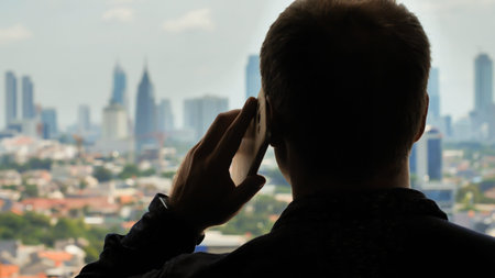 Man is talking on the phone in the background of the city.