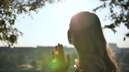 A young blonde 18 year old girl prays with folded hands.の写真素材