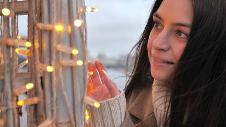 Happy girl on the background of Christmas garland. Copy space.の写真素材