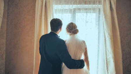 The groom approaches his young bride on their wedding dayの写真素材