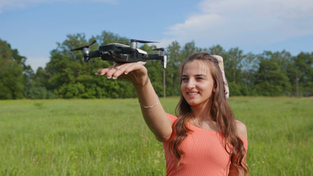 A beautiful girl launches a drone in her palm.