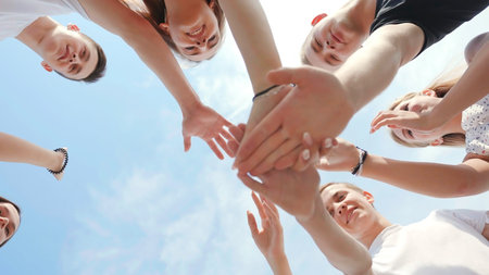 Friendly friends clasp hands as a sign of strong friendship and teamwork.
