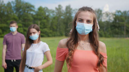 Pandemic concept. A group of students stand in a row in masks.の写真素材