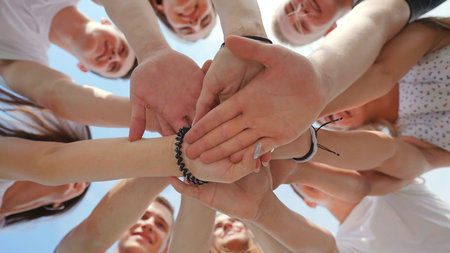 Friendly friends clasp hands as a sign of strong friendship and teamwork.