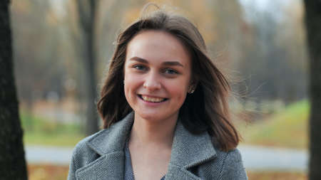 Portrait of a smiling young girl in an autumn park.の写真素材