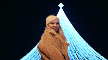 Girl posing against the backdrop of urban Christmas illumination.の写真素材