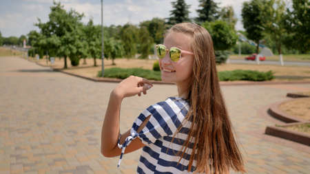 A young teenager girl poses in a summer day in a striped dress.の写真素材