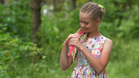 Teenage girl with multi-colored dreadlocks in the forest.の写真素材