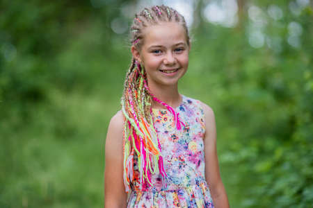 Teenage girl with multi-colored dreadlocks in the forest.の写真素材
