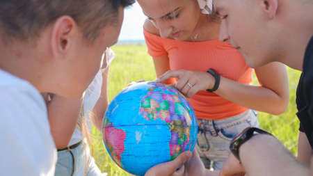 Friends are examining the globe of the earth.の写真素材