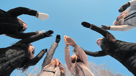 Girls friends join hands in the center on a winter day.の写真素材