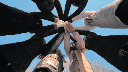 Girls friends join hands in the center on a winter day.