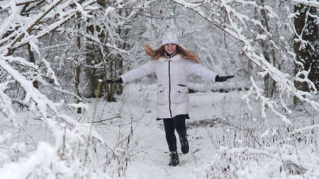 The girl runs through the snowy magic forest.の写真素材