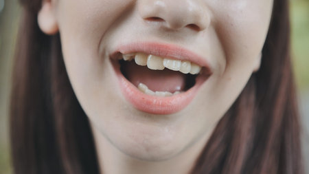 The young girl opens her mouth and shows her tongue. Stamatology theme.の写真素材