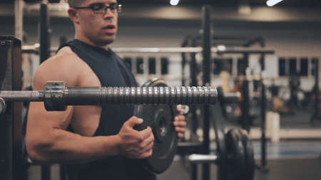 The male athlete arab changes the weight on the barbell.の写真素材