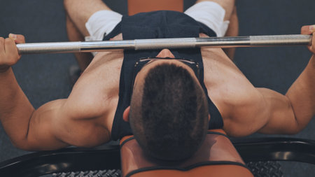 An Arab man shakes his chest with a barbell lying down.の写真素材
