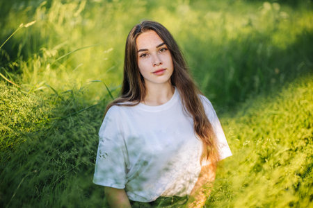 Portrait of a young girl in the green grass on a summer day.の写真素材