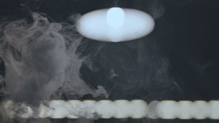 The rising smoke in the hookah bar against the background of the lamp.