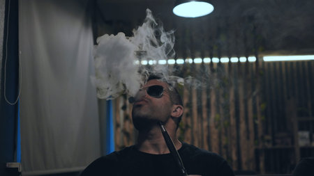 Arabic jordanian young man smokes a hookah.