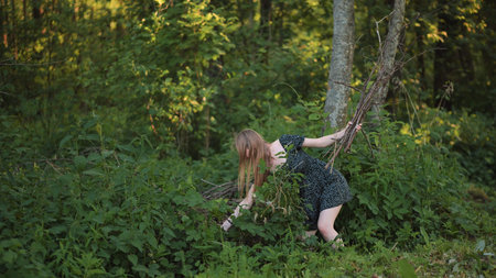 A young girl collects brushwood for a fire at a picnic.