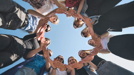 A group of girls makes a circle from their palms hands.