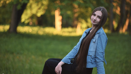 Long-haired girl posing in the park in the evening.