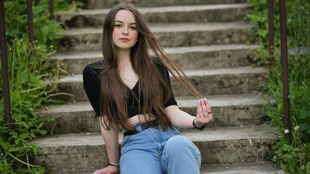 Nice girl posing while sitting on the stairs.